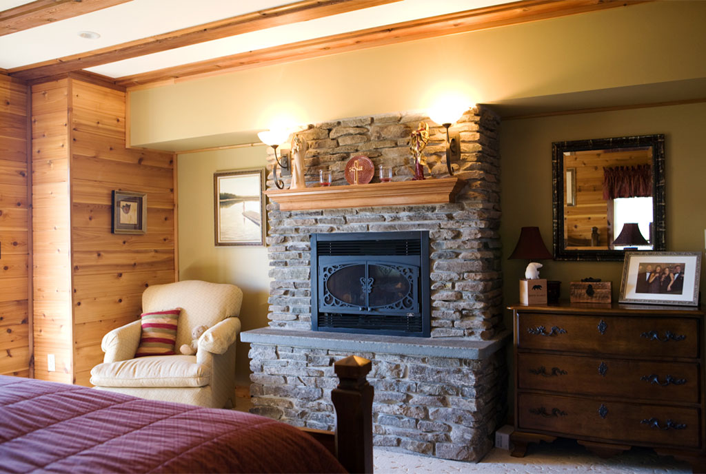 Beaver Mountain Log Homes Bass Cedar Timber Home Bedroom and Stone Fireplace