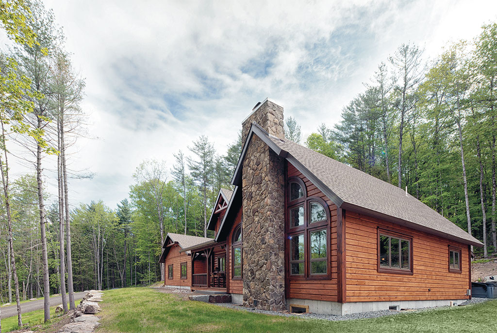 Beaver Mountain Log Homes Black Bear Lodge Timber Home Exterior Front and Stone Chimney