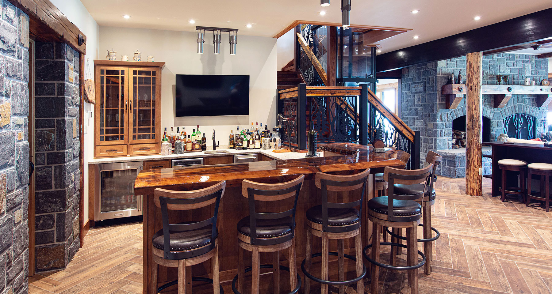 Custom bar with wine cellar, elevator and stonework in Adirondacks